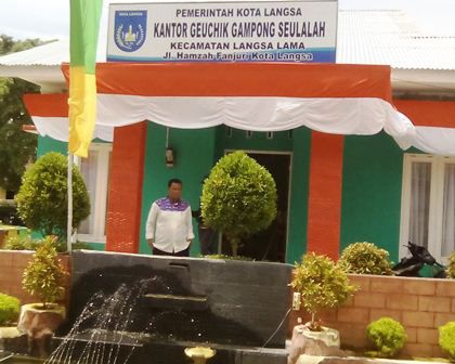 Geuchik Gp. Seulalah Induk saat meninjau kebersihan lokasi sekitar kantor. (Foto Boy)